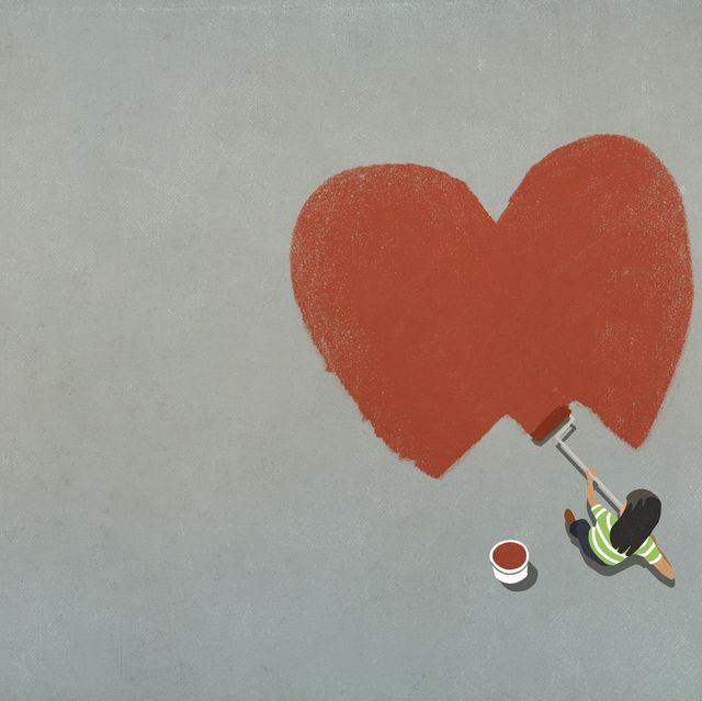 woman painting red heart with paint roller