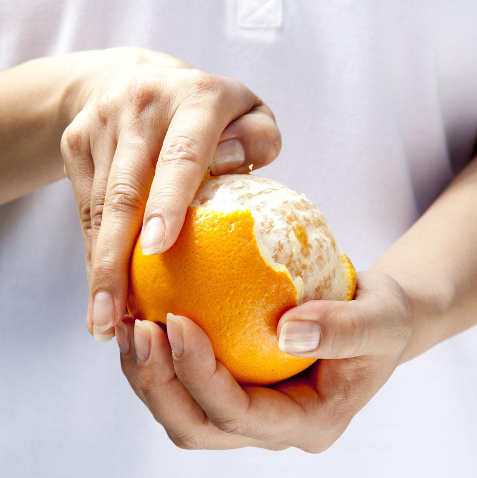 woman peeling an orange