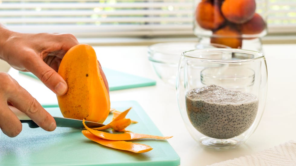 woman peeling mango chia seeds pudding with fresh fruits