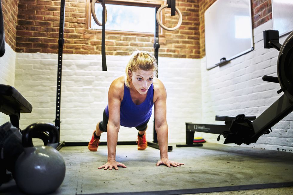 woman performing slow push up in home gym in a converted garage