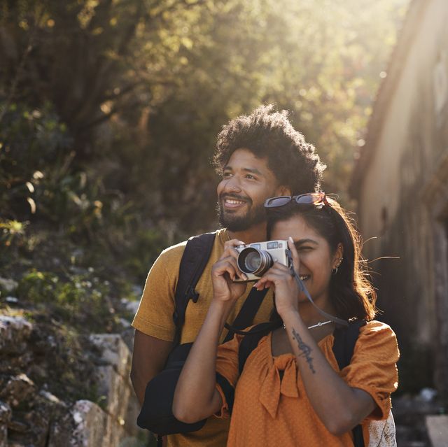 woman photographing through camera by boyfriend