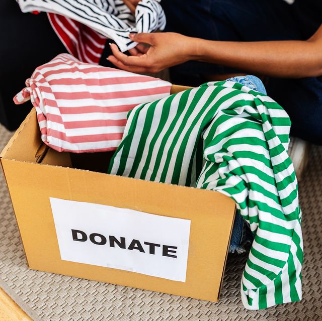 woman placing clothes in donation box at home