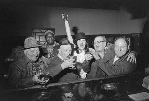 woman posing with men in a bar