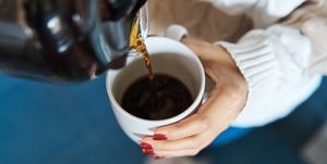 woman pouring herself hot coffee to a mug