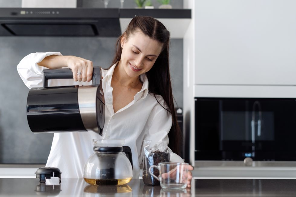 woman pouring hot water into teapot