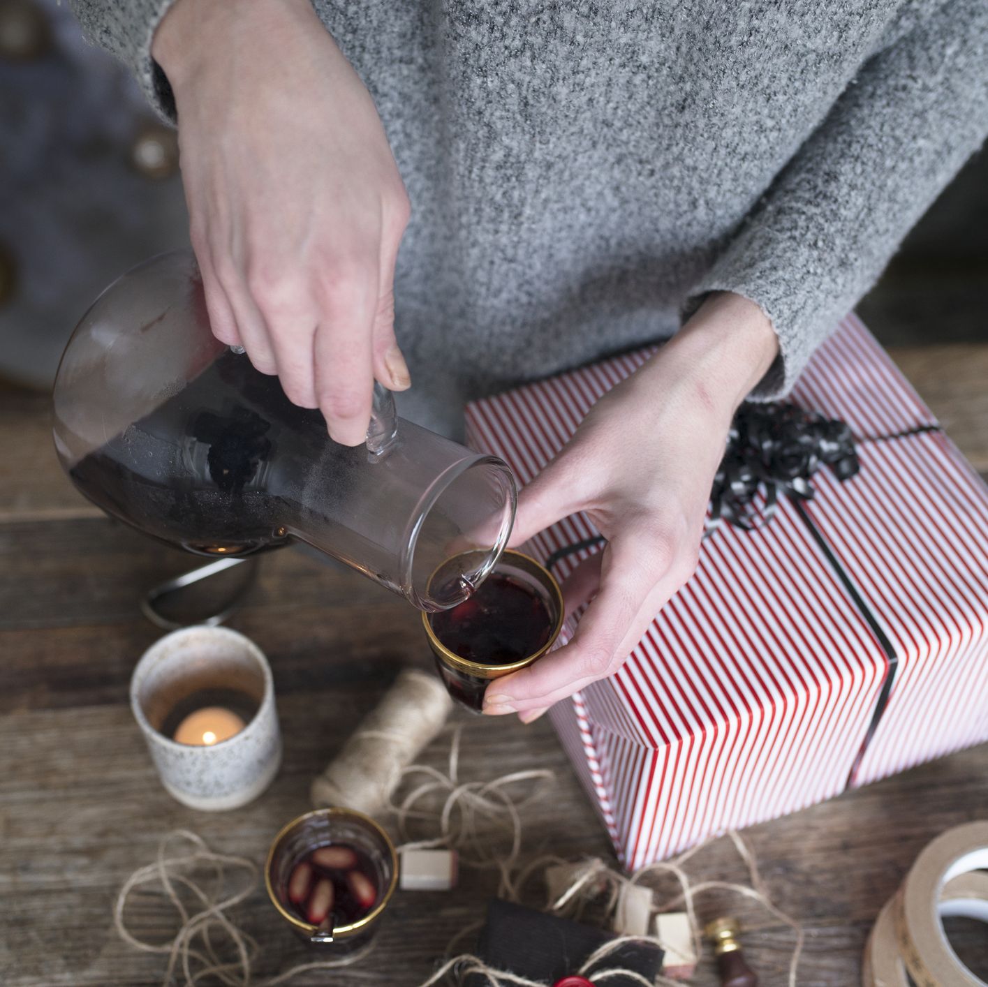 woman pouring mulled wine while packing present