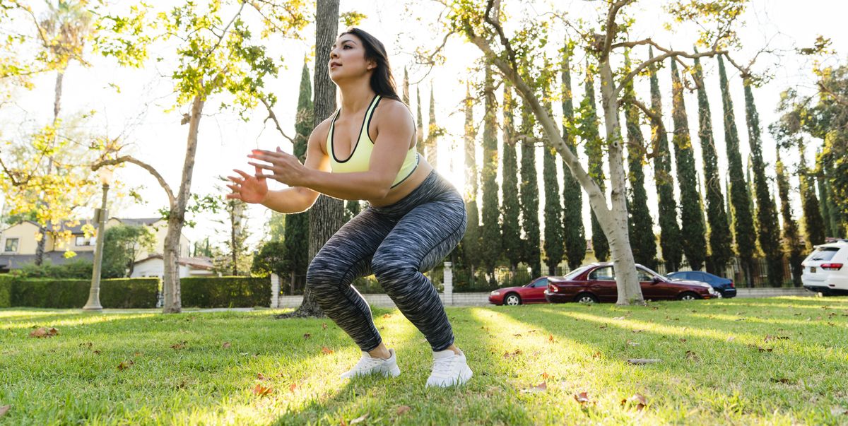 woman practicing jump squats in park