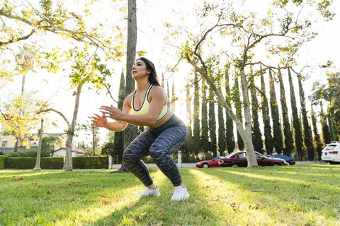 Woman practicing jump squats in park