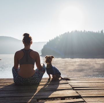 woman practicing yoga at wild lake