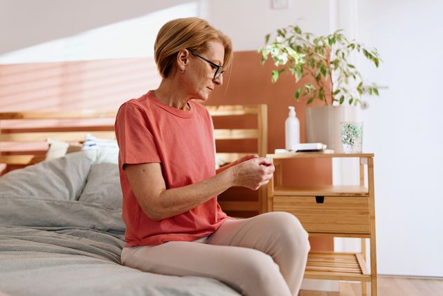 woman preparing to put on an adhesive patch for hormone replacement therapy