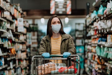 woman pushing supermarket cart during covid 19