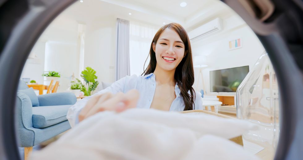 woman put sheet in washer