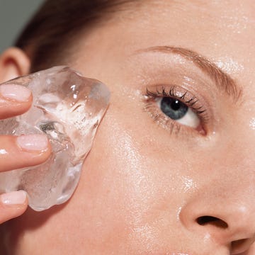 Woman putting ice on her face Woman putting ice on her face