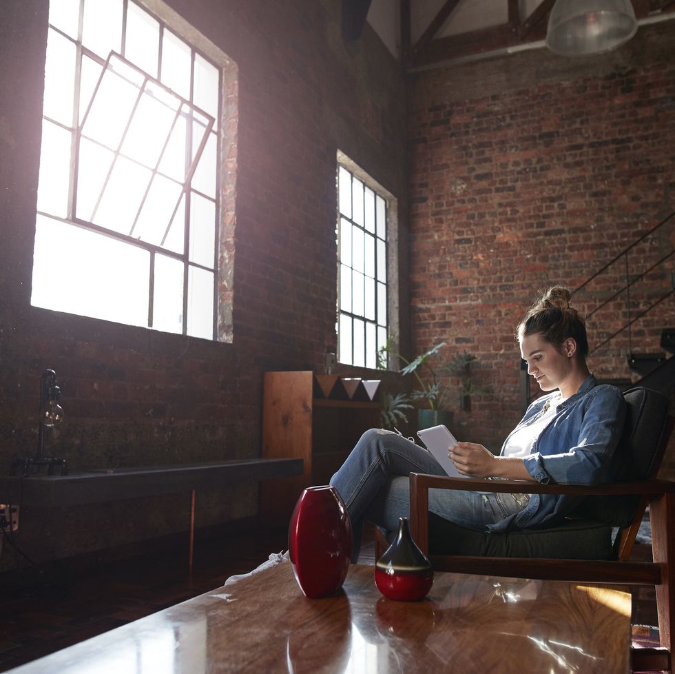 Woman reading on tablet, in loft apartment