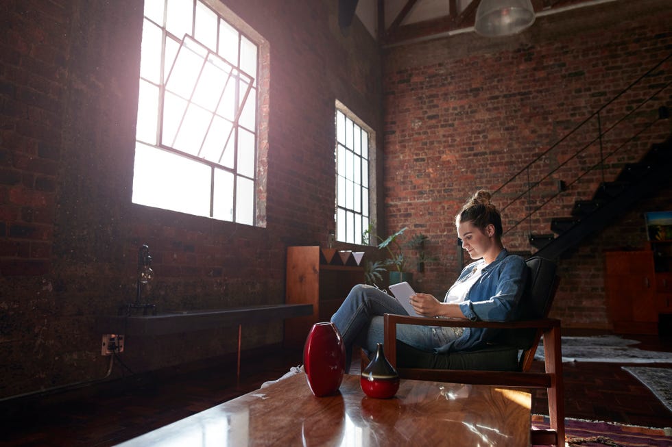 Woman reading on tablet, in loft apartment