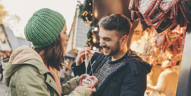 Woman receiving a gingerbread heart from her boyfriend on the Christmas Market