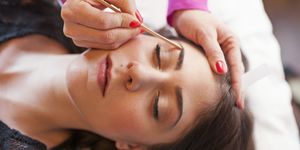 woman receiving eyebrow waxing