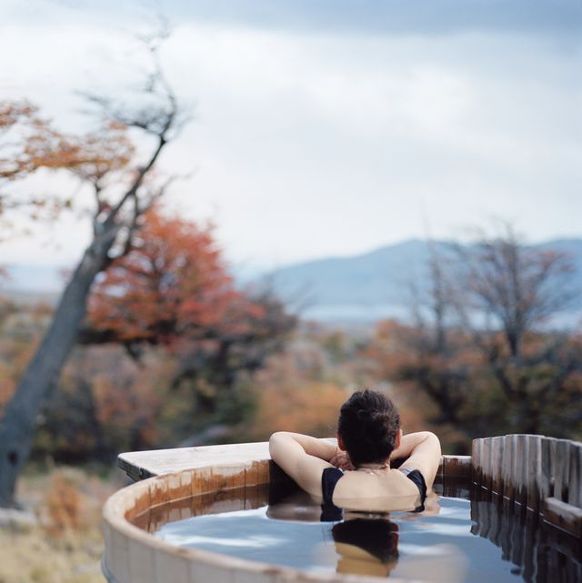 woman relaxing in wood-fired mountainside hot tub