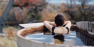 woman relaxing in wood fired mountainside hot tub