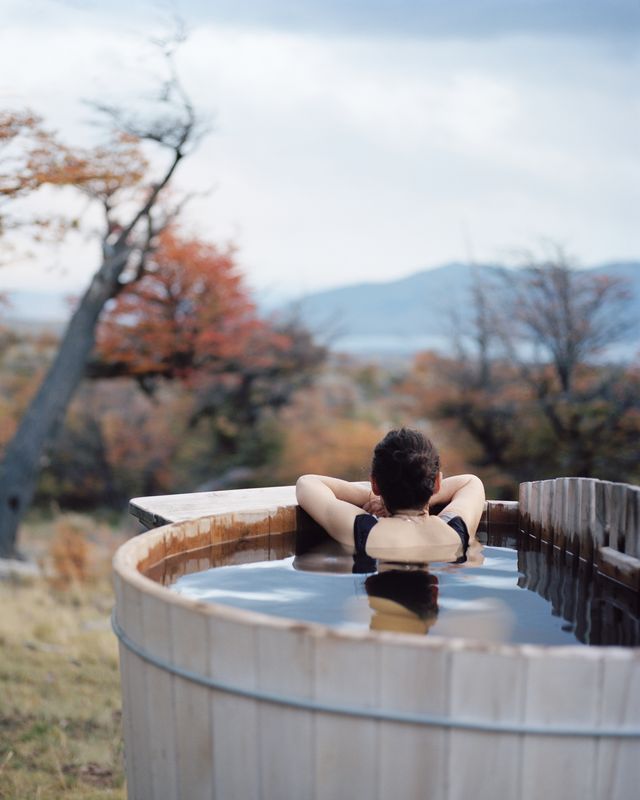 woman relaxing in wood fired mountainside hot tub