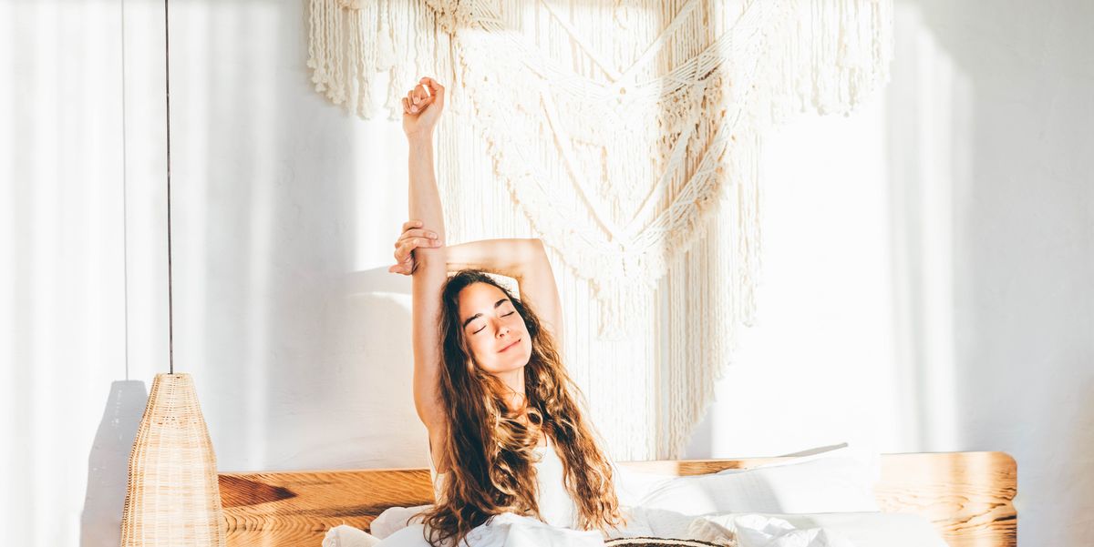 woman relaxing on a bed. woman stretching hands in bed.