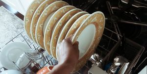 woman removes plates from dishwasher