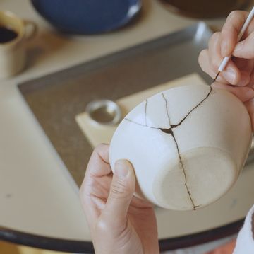 woman repairing broken pottery kintsugi