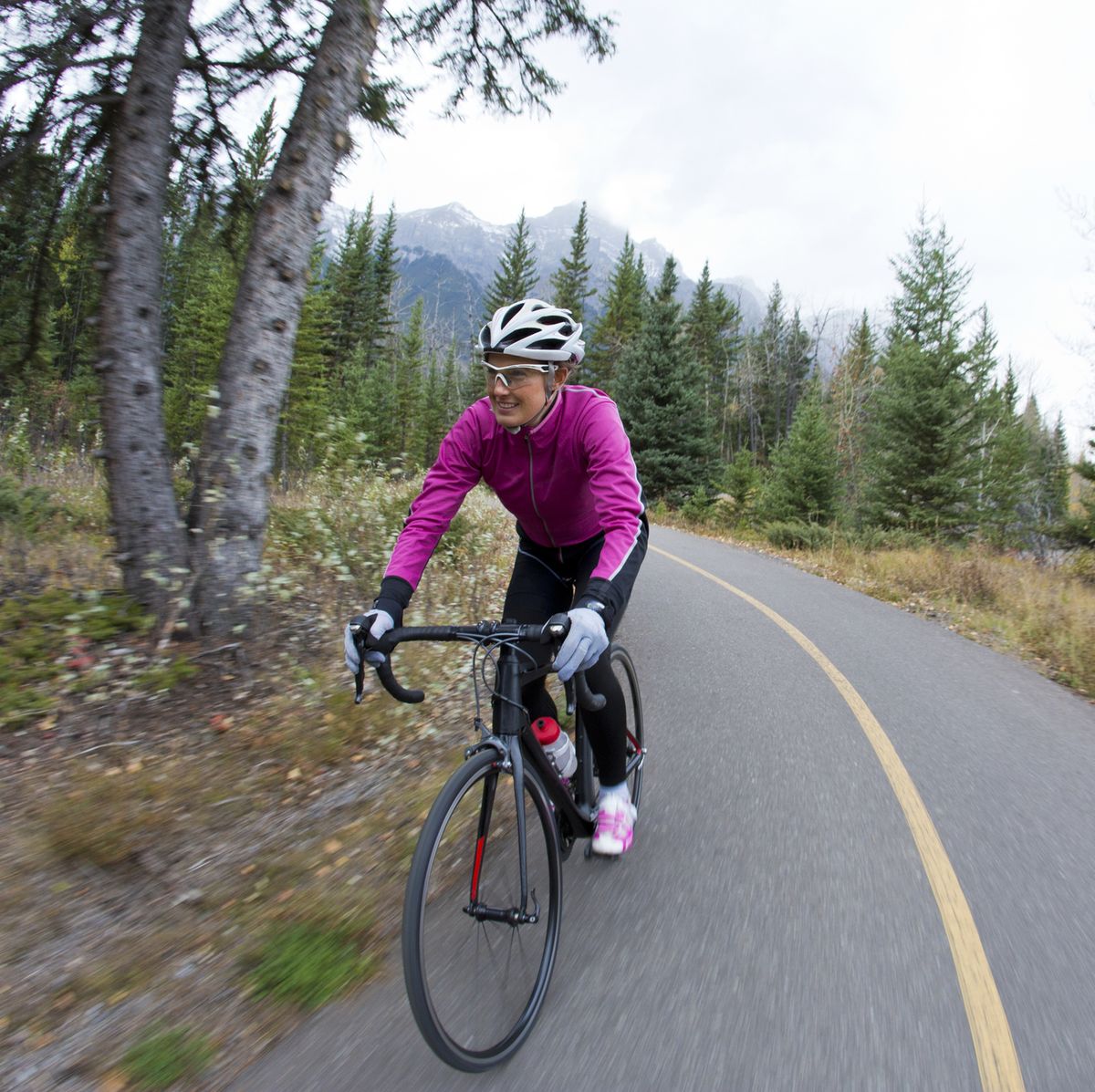 a woman rides her road bike along the trans canada trail bikepath, cycling efficiency tips