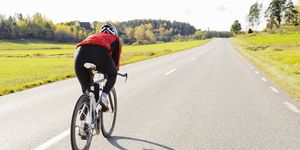 Woman riding bike down country road