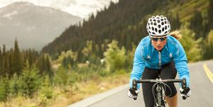 Woman riding her road bicycle up mountain road