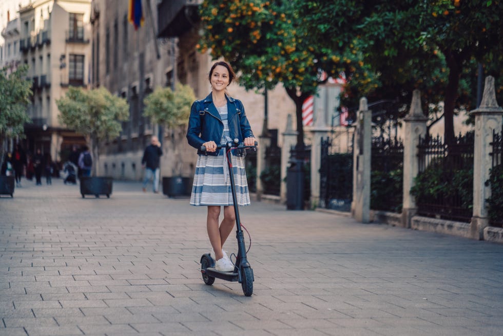 Woman riding motor scooter at Plaza de la Virgen in Valencia