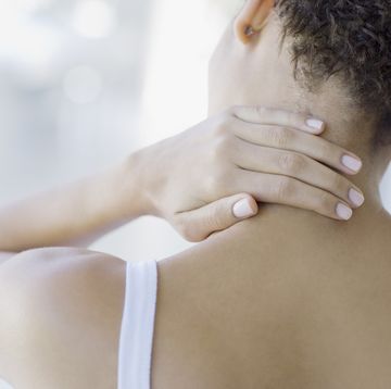 woman rubbing sore neck