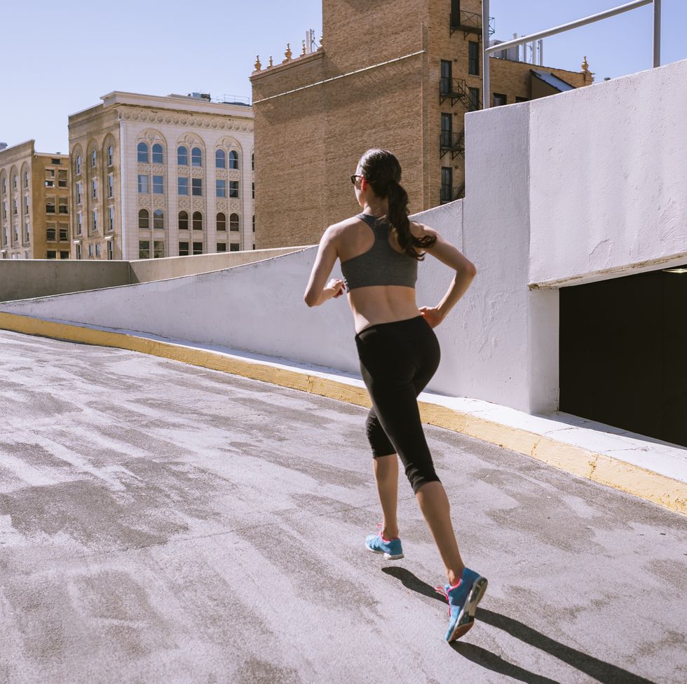 woman runner climbing parking garage in city