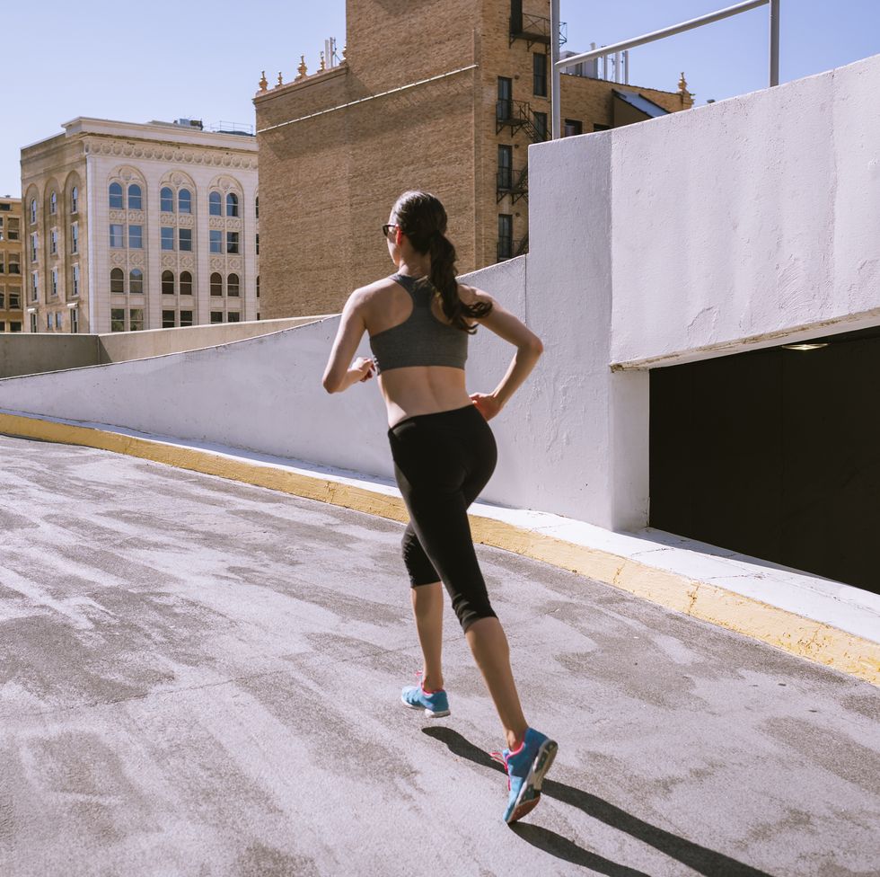 woman runner climbing parking garage in city