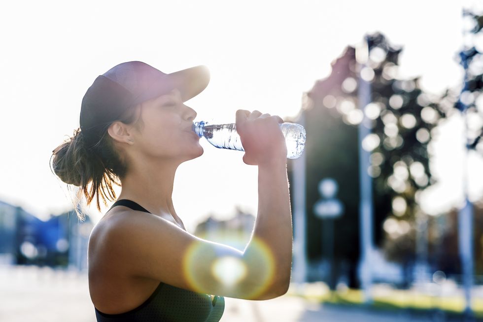 woman runner drinking from water bottle