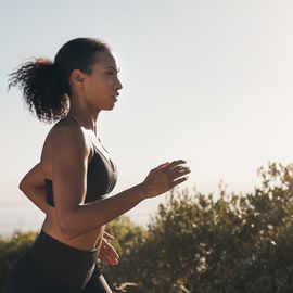 woman, runner profile and road with trees, exercise and fitness outdoor for sport race. young female person, running and workout of an athlete doing a run at morning for health with training