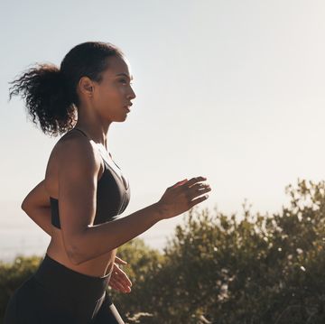 woman, runner profile and road with trees, exercise and fitness outdoor for sport race. young female person, running and workout of an athlete doing a run at morning for health with training