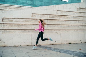 woman running against modern building