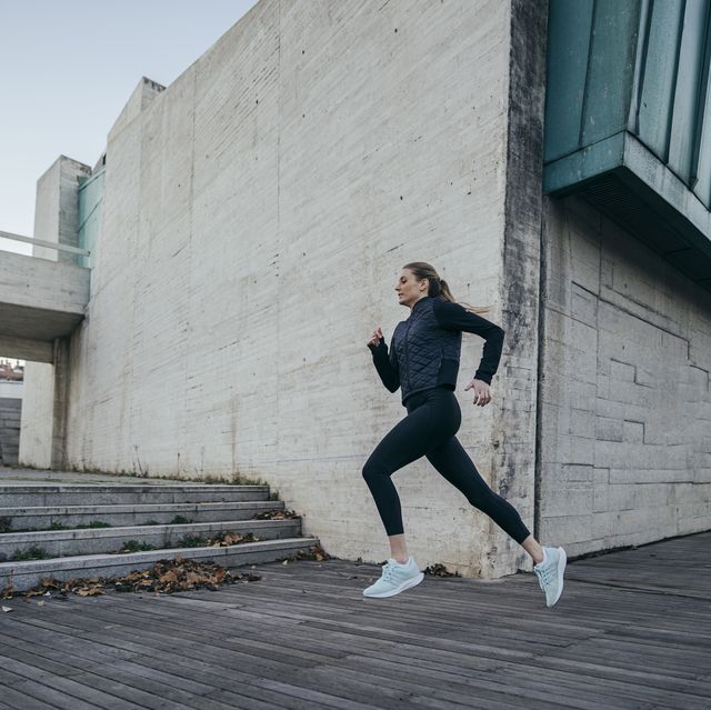 woman running against modern building