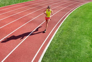 a woman running alone on a synthetic sports track painted with striped white lines