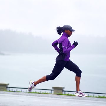 woman running along waterfront path