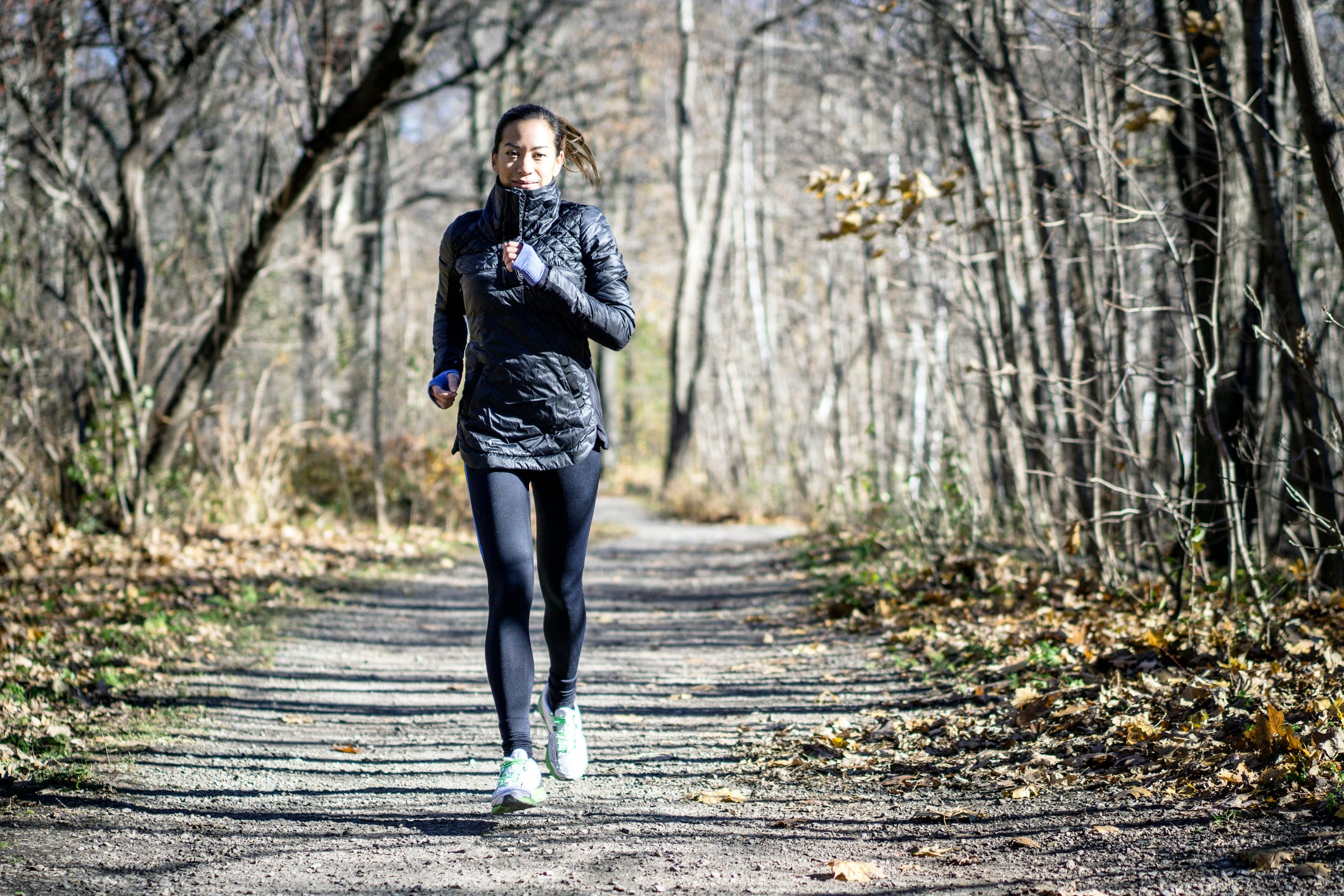 woman running on dirt path in autumn