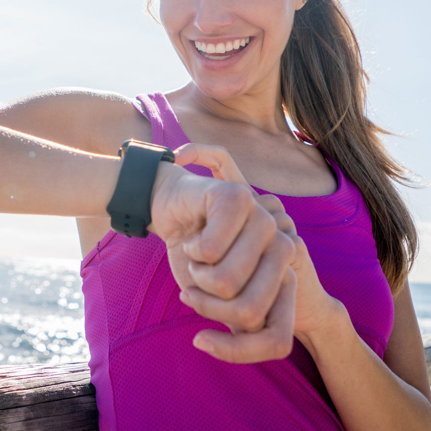 Woman running outdoors using a smart watch Woman running outdoors using a smart watch