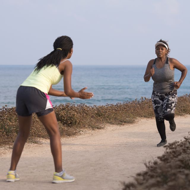 a woman runs with coach support