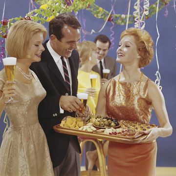 woman serving appetizers at party, smiling