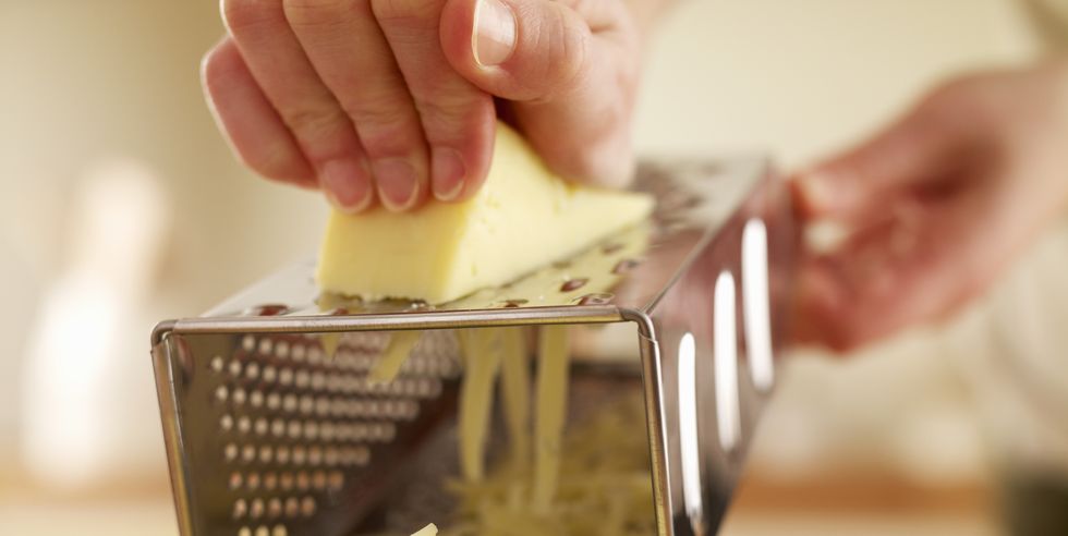 woman shredded cheese with grater