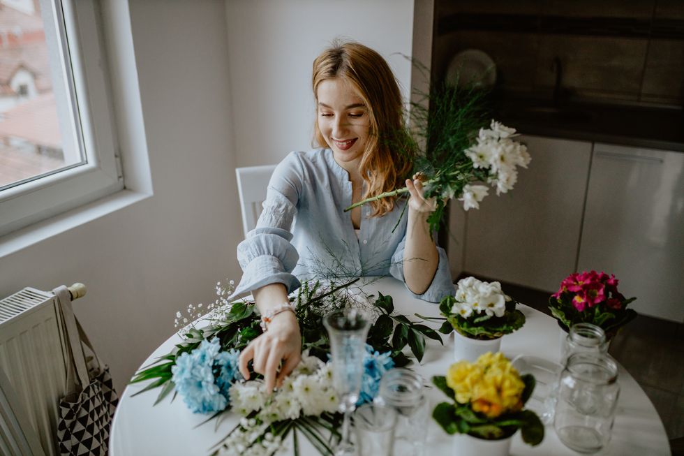 woman sitting at home and arranging flowers