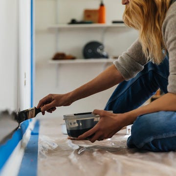 Woman sitting painting wall at home woman sitting painting wall at home