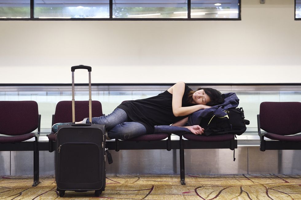 woman sleeping on a row of airport seats