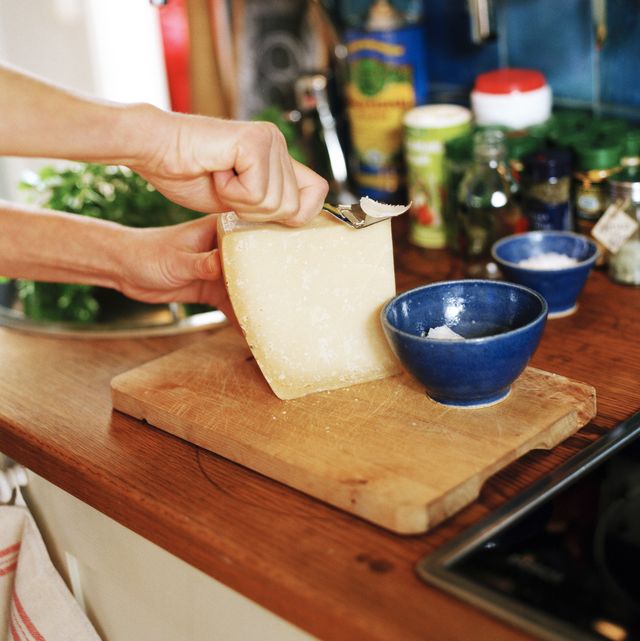 woman slicing cheese on chopping board